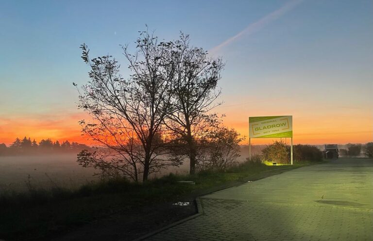 Firmenschild bei Sonnenuntergang in einer nebeligen Landschaft